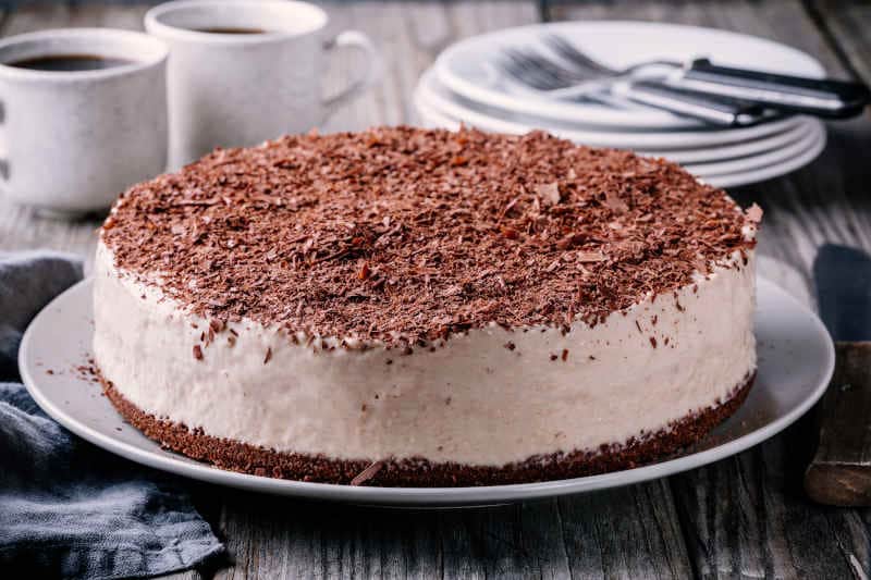 Cold chocolate cheesecake on a plate on wooden rustic background