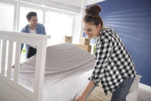 Couple putting their new mattress on the bed
