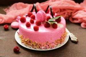 Amazing pink cake with raspberries on an iron table