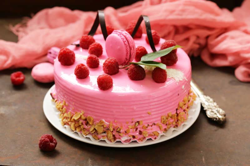 amazing pink cake with raspberries on an iron table