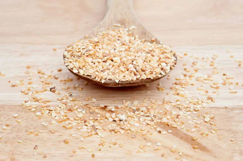 Minced garlic on wooden serving spoon