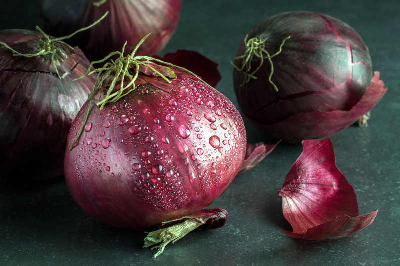 Fresh red onions with water droplets on those