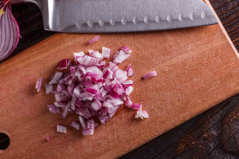 Red onion cut on a wooden board.