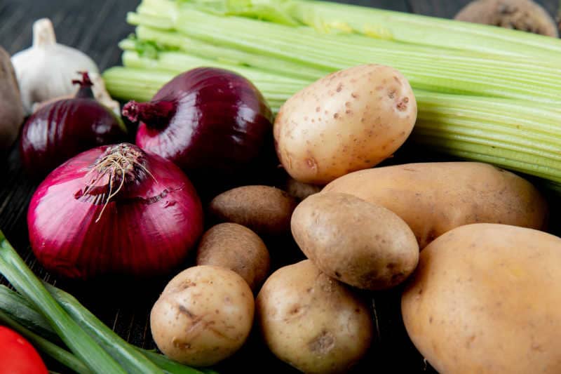 Close-up view of vegetables as onion, potato, celery, scallion