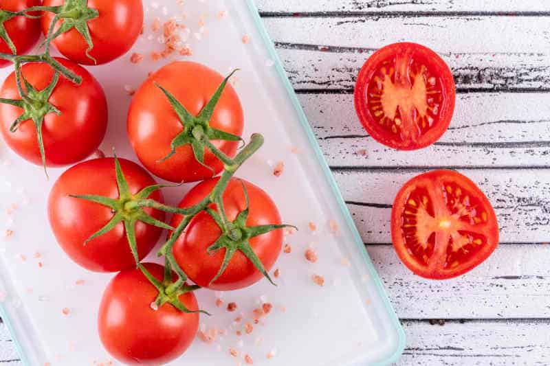 Tomato sea salt in white plastic cutting board top view