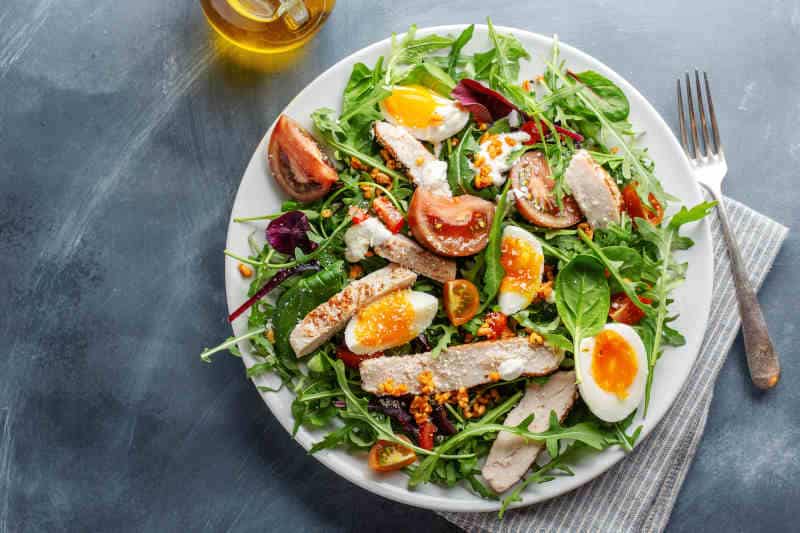 Tasty appetizing salad with turkey, eggs, bulgur and vegetables served on plate