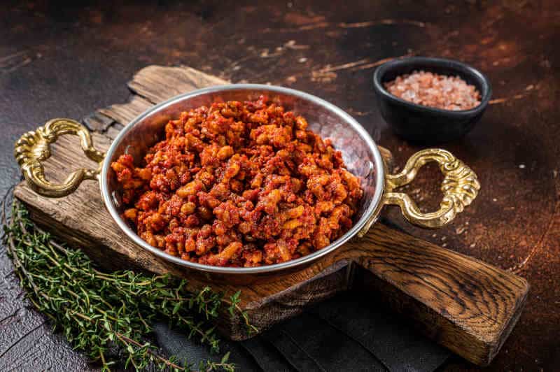 Hot ground beef stewed with tomato sauce and spices in a skillet with spices