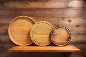 Washed wooden cutting board at shelf on brown wooden background