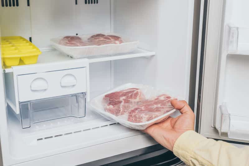 Man taking out frozen meat from freezer