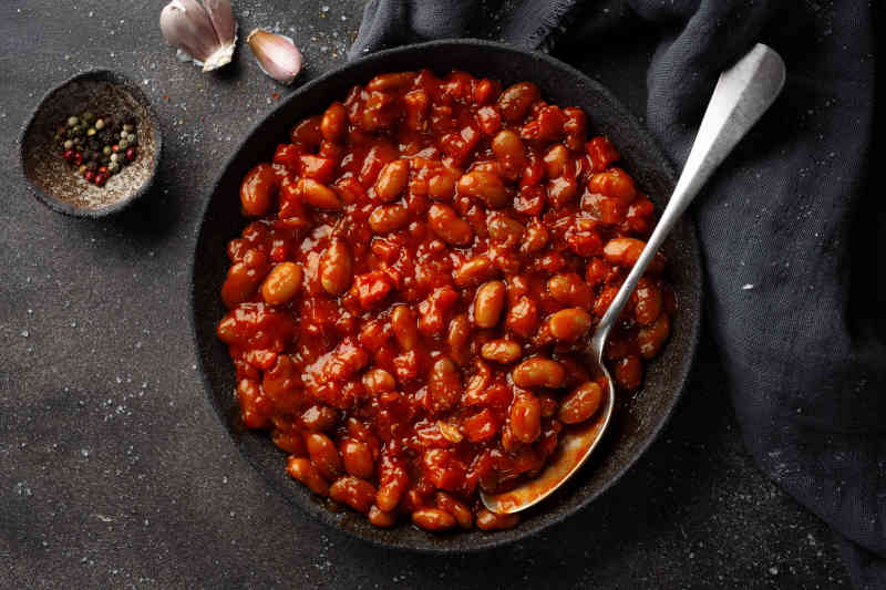 Tasty appetizing homemade stuffed or baked bbq beans with vegetables