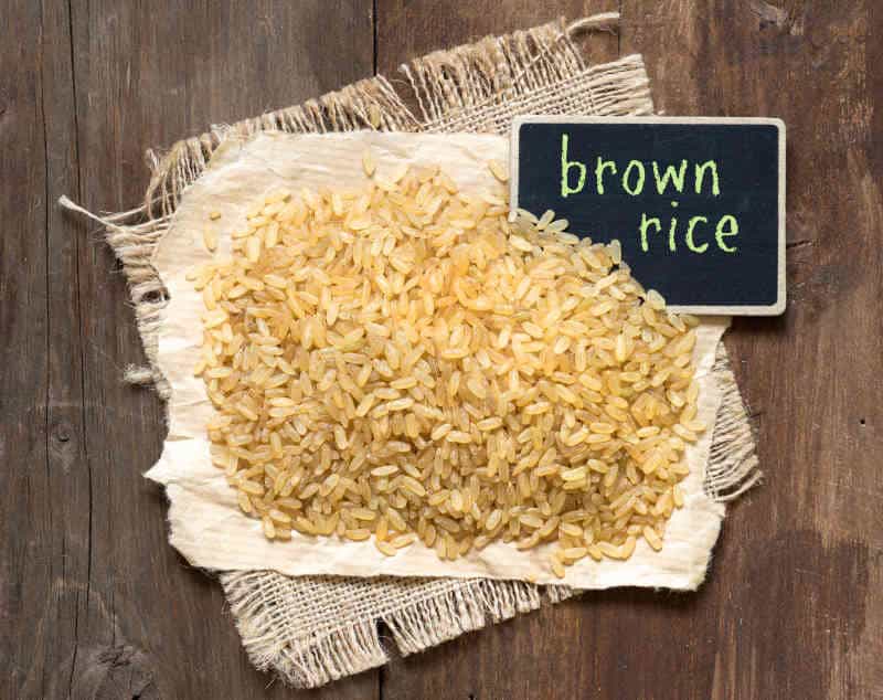 Brown rice with small chalkboard on a wooden table