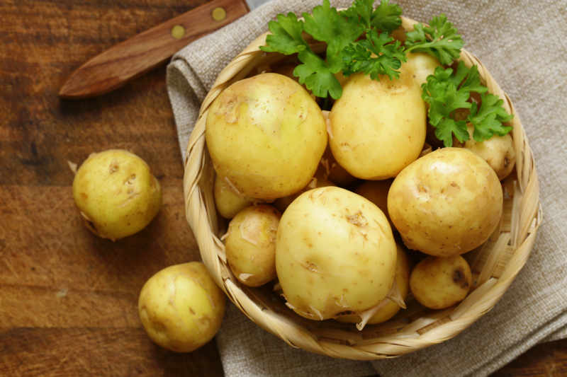 Fresh organic raw potatoes in a basket