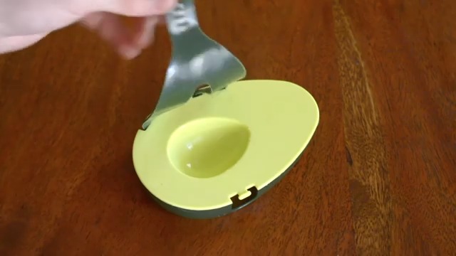 Opening avocado saver's cover before placing avocado