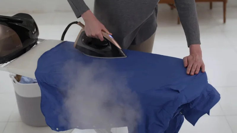 Ironing clothes with steam generator iron