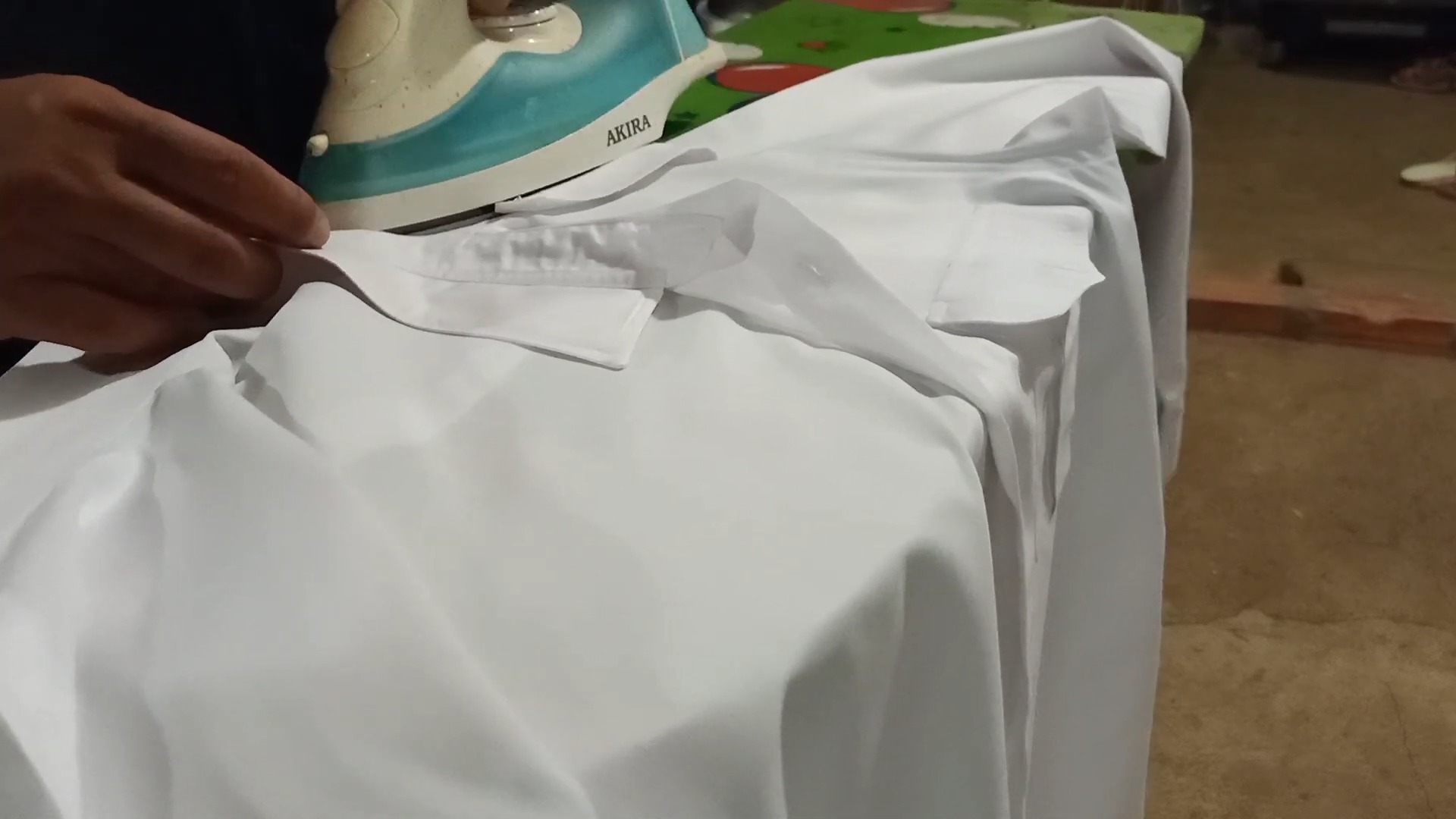 Ironing white Polyester shirt on ironing board