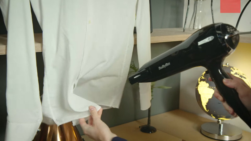 Using hair dryer to remove wrinkles from clothes